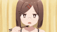 a girl with glasses is holding chopsticks to her mouth