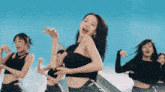 a woman in a black top is dancing with a group of other women