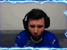 a man wearing headphones and a blue shirt with a puma logo