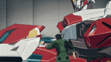a man in a green jacket is standing next to a large robot