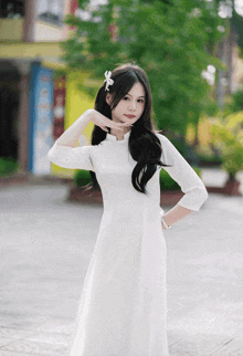 a girl in a white dress with a bow in her hair