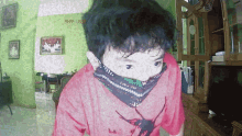 a boy wearing a red shirt with a spider on it stands in a living room
