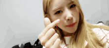 a young woman is making a heart shape with her hands .