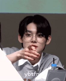 a boy wearing glasses and a sweater that says ybfn