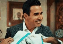 a man is holding a baby in his arms and smiling