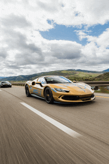 a gold sports car is driving down a highway