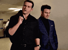 two men in suits are standing next to each other