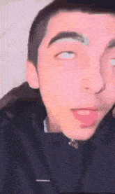 a close up of a young man 's face with his eyes closed