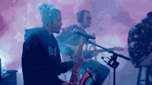 a man playing a saxophone in front of a microphone