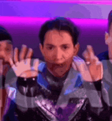 a blurry picture of a man making a funny face with his hands in the air