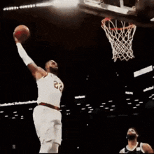 a basketball player is jumping in the air while holding a basketball in his hand .