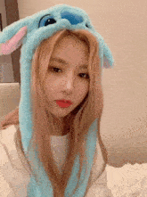 a woman is wearing a blue bunny hat with ears .