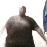 a blurred image of a man in a black shirt dancing in a room .
