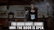 a woman in a maid outfit is standing in a room with the words the door is open