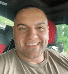 a man with a beard is smiling for the camera