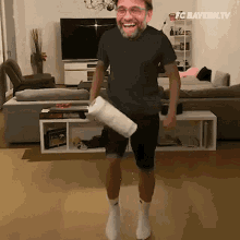a man in a black shirt is holding a roll of toilet paper in his hand