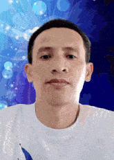 a man in a white shirt is looking at the camera with a blue background behind him