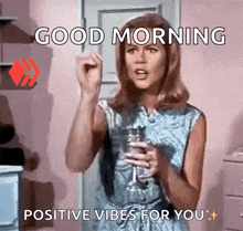 a woman is holding a glass of wine and saying good morning positive vibes for you .