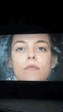 a close up of a woman 's face in water on a screen .