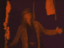 a person in a brown coat is standing in front of a purple wall