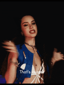 a woman in a blue jacket with the words that 's mineee on the bottom