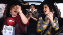 a group of people are singing in a car with a sign that says singing in the car