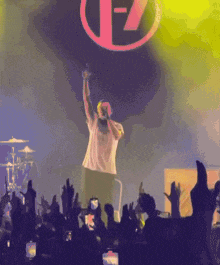 a man singing into a microphone in front of a crowd with a f7 logo on the stage