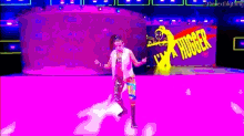 a woman is dancing on a purple stage in front of a sign that says nugget .