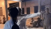 a group of people are standing in front of a building and a woman is holding a man 's arm .