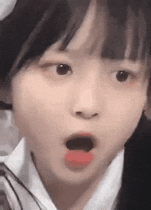 a close up of a girl 's face with her mouth open and her tongue out .