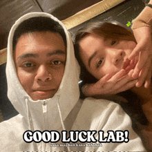 a man and a woman are posing for a picture and the caption reads good luck lab