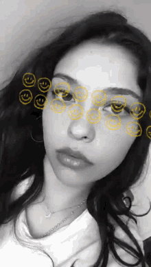 a black and white photo of a woman with smiley faces drawn on her face