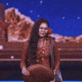 a woman in a red dress with a flower in her hair is standing on a stage holding a basket .