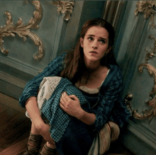 a woman sits on the floor with her legs crossed