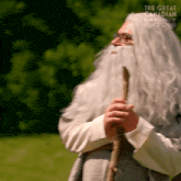 a man with a beard and glasses is holding a cane and the words the great canadian baking show can be seen behind him