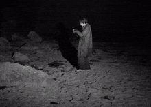 a black and white photo of a person on a beach