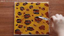 a person is using a spatula to paint the stroke black on a painting