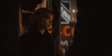 a woman is smoking a cigarette in front of a cue sign