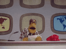 a muppet is holding a piece of paper in front of a podium