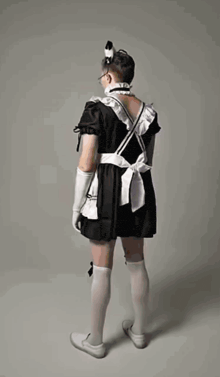 a man in a maid costume is standing in front of a white background