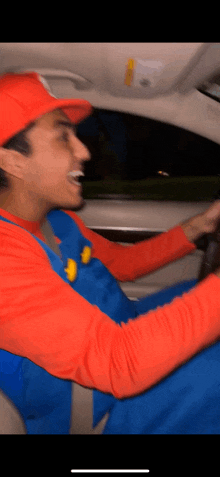 a man in a mario costume is driving a car at night .