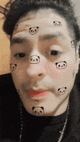 a close up of a man 's face with panda bears on it