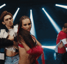 a man in a red and white shirt with the letter s on it is dancing with a woman