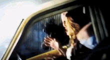 a blurry picture of a woman sitting in a car looking out the window