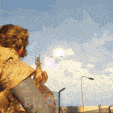 a person holding a gun in front of a blue sky with the word eu on the bottom
