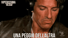 a man wearing headphones with the words una peggio dell ' altra below him