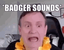 a man with a lei around his neck is making a funny face while wearing a badger sounds sign .