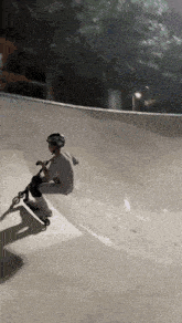 a person is riding a scooter down a ramp at a skate park