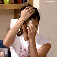 a woman wearing a t-shirt that says easy wipes her face