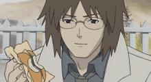 a man with glasses is eating a sandwich